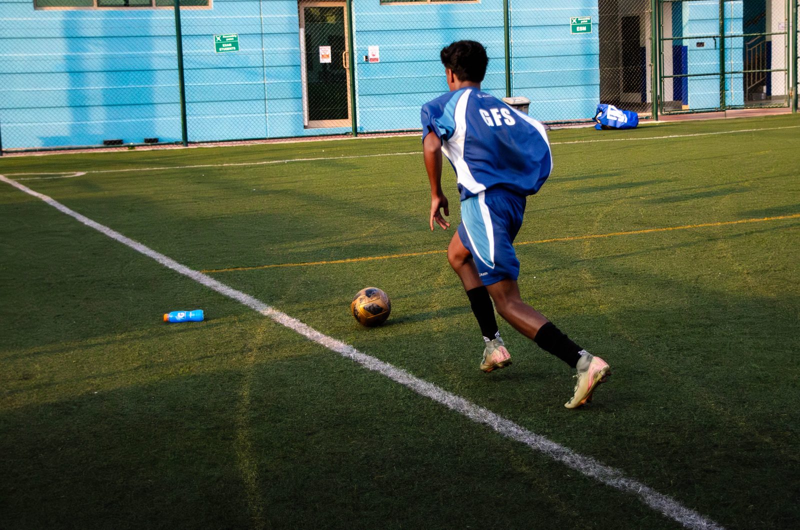 Dev on the ball in GFS kit, driving forward on the pitch
