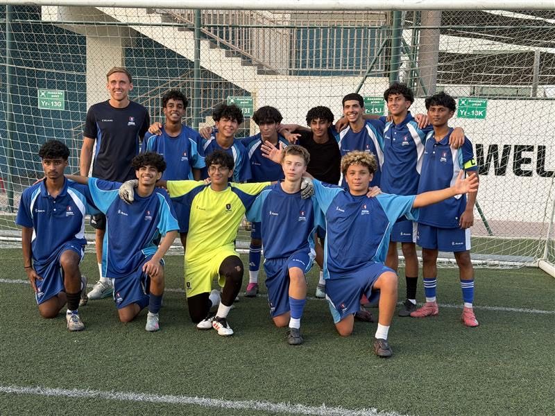 Dev with his school football team posing in front of the goal
